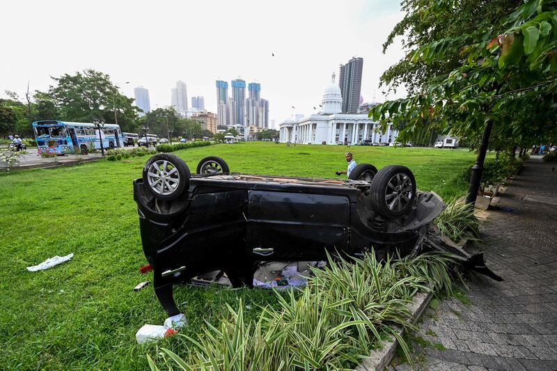 Destroyed vehicles litter the street after anti-government protesters rioted in Colombo. AFP