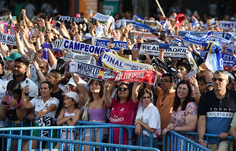 Real Madrid supporters celebrate while awaiting their team's arrival at Cibeles square. Getty