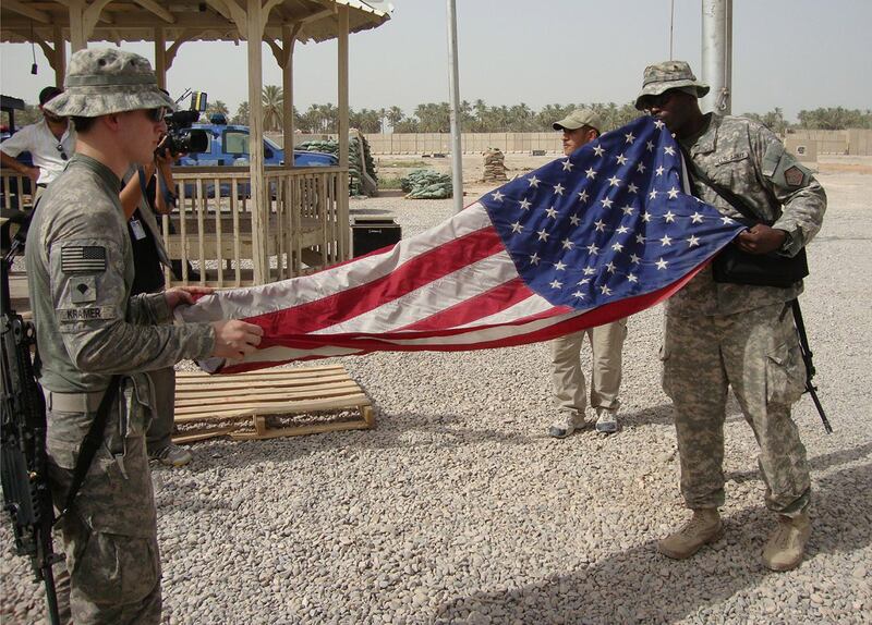 US soldiers fold the American flag while preparing to leave Scania military base in Hila, south of Baghdad, in 2010. EPA