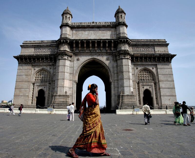 A women walks past the Gateway of India in the Colaba district of Mumbai April 16, 2005. The World Travel and Tourism Council is predicting that India will be the third-fastest growing tourism market in the next 10 years. Photographer: Paul Hilton/Bloomberg News
