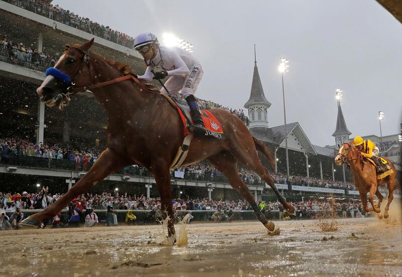 FILE - In this May 5, 2018, file photo, Mike Smith rides Justify to victory during the 144th running of the Kentucky Derby horse race at Churchill Downs in Louisville, Ky. The Run For The Roses is usually held on the first Saturday of May. Because of the pandemic, hold those mint juleps until Labor Day weekend, when the first leg of the Triple Crown is crammed into a slot that also marks the start of college football season. (AP Photo/Morry Gash, File)