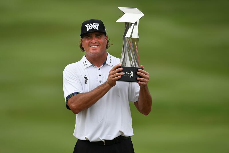 Pat Perez of the US lifts the trophy after winning the 2017 CIMB Classic golf tournament in Kuala Lumpur on October 15, 2017. / AFP PHOTO / Mohd RASFAN