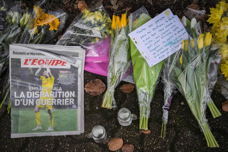 Flowers, candles, and a sign that reads "All of our thoughts are for you Emiliano Sala" are left with newspaper 'L'Equipe'  in La Chapelle-sur-Erdre. AFP