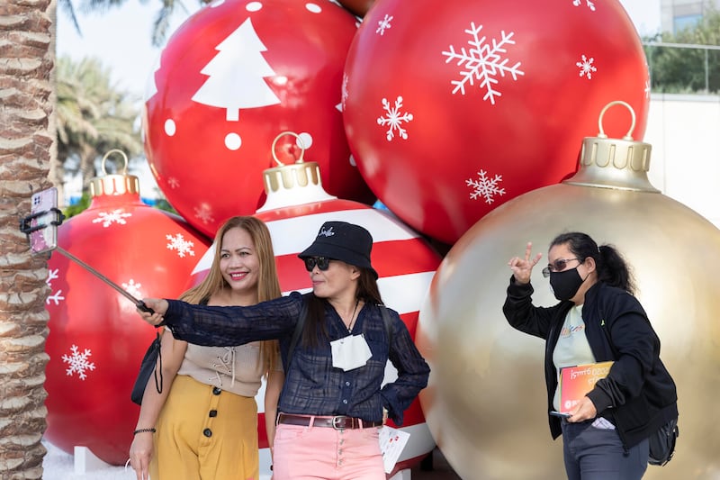 Expo visitors grab a selfie with some giant-sized Christmas baubles.