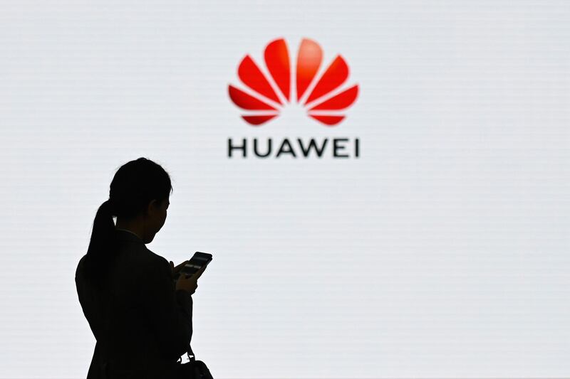 (FILES) This file photo taken on March 6, 2019 shows a staff member of Huawei using her mobile phone at the Huawei Digital Transformation Showcase in Shenzhen in China's Guangdong province. Chinese telecommunications giant Huawei said on December 31, 2019 that "survival" was its first priority after announcing 2019 sales were expected to fall short of projections as a result of US sanctions. / AFP / WANG ZHAO
