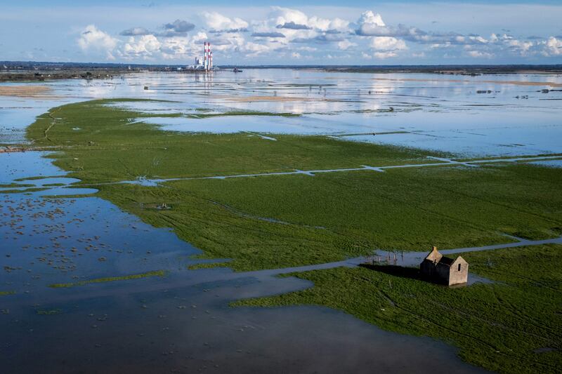 A field is flooded by a large equinox tide, with a major coal plant in the background, in the Lavau-sur-Loire commune, western France.  AFP