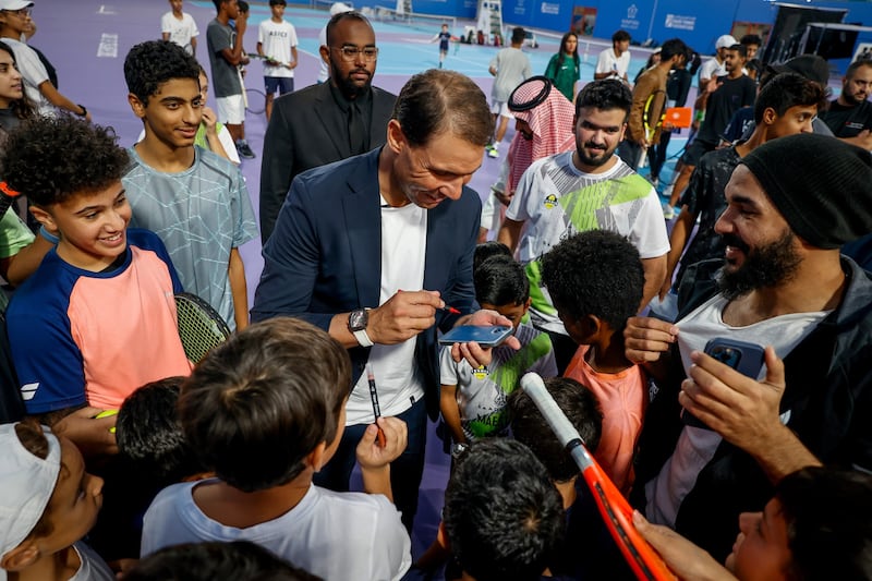 Rafael Nadal signs autographs for children after the tennis clinic held at Mahd Academy.