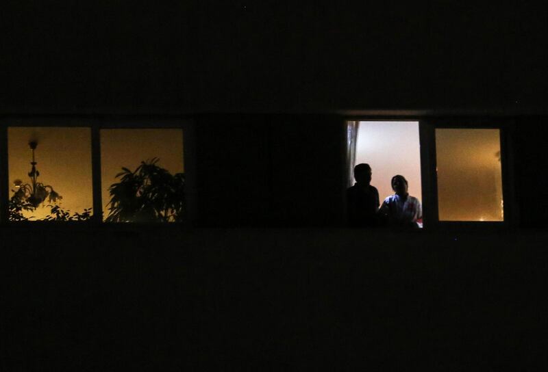 A couple look out of a window during confinement at home due to the COVID-19 coronavirus pandemic in the Iranian capital Tehran.  AFP