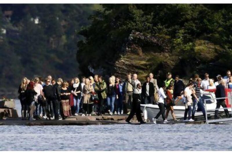 Survivors and families of the Utoeya shooting massacre arrive at Utoeya island, 40km north-west of Oslo, yesterday, where about 1,000 people were expected to visit ahead of a national day of remembrance today. Norwegian Anders Behring Breivik has admitted killing 77 people last month, including eight in a bombing in central Oslo. Fabrizio Bensch / Reuters