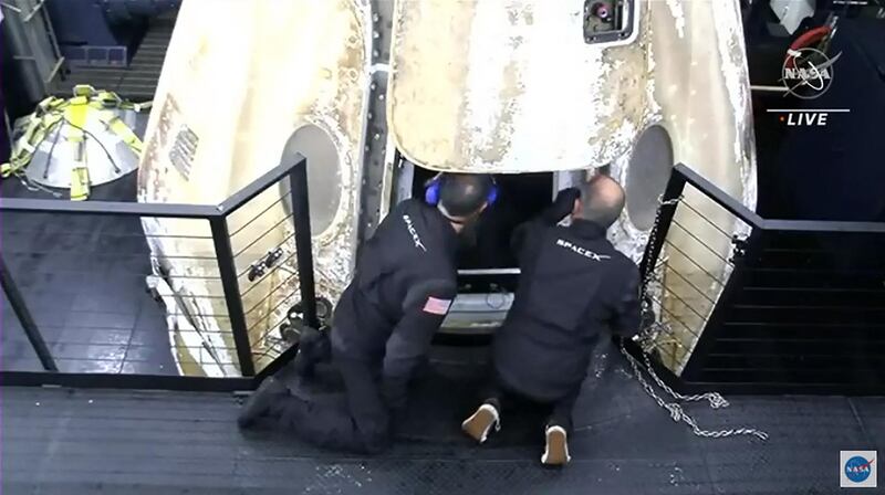 The recovery team open the hatch of the SpaceX's Crew Dragon, following its return to Earth from the International Space Station. AFP