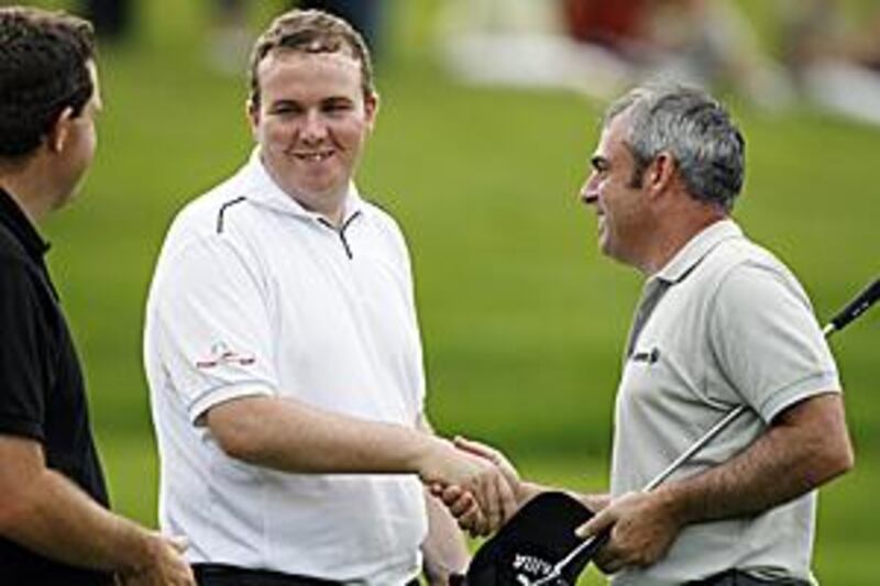 Shane Lowry shakes hands with compatriot Paul McGinley, right, after completing his first professional round of golf on the first day of the European Open at the London Club yesterday.