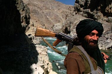 FILE - In this Oct.  8, 1996 file photo, a Taliban soldier patrols the entrance to the Panjshir Valley, north of Kabul.  In August 2021, the last remnants of Afghanistan’s shattered security forces have vowed to resist the Taliban in the remote Panjshir Valley north of Kabul, that has defied conquerors before.  Under the leadership of late charismatic guerrilla fighter Ahmad Shah Massoud, fighters in the Panjshir Valley held off the Soviets in the 1980s and the Taliban a decade later.  Any attempt to re-enact his exploits appears likely to fail, posing little threat to the country's new Taliban rulers. .  (AP Photo / John Moore, File)