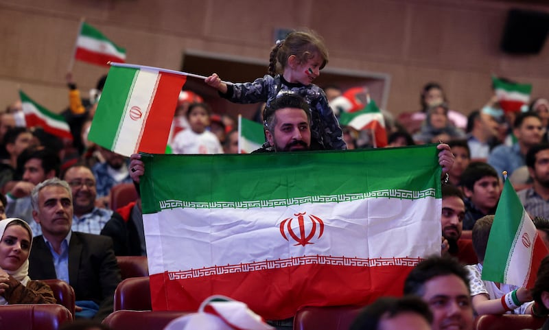 Iranian fans display flags during the match.  AFP