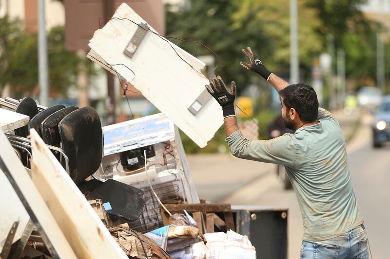 A volunteer disposes of an electrical item as the clean-up effort continues after flooding in Euskirchen, North Rhine-Westphalia, western Germany.