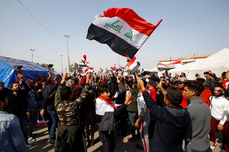 Iraqi demonstrators hold the Iraqi flag as they chant slogans during ongoing anti-government protests in Najaf, Iraq February 6, 2020. REUTERS/Alaa al-Marjani