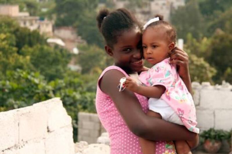 Mendji Bahina Sanon, aka Fedora, a 12-year-old schoolgirl who survived nine days under rubble, playing with a neighbourÕs child at her home in Petionville, a leafy suburb of Port-au-Prince. By James Reinl/The National?