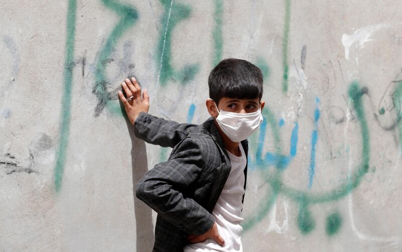 A Yemeni child wearing a protective face mask leans against a wall amid concerns over the spread of the coronavirus in Sanaa, Yemen.  EPA