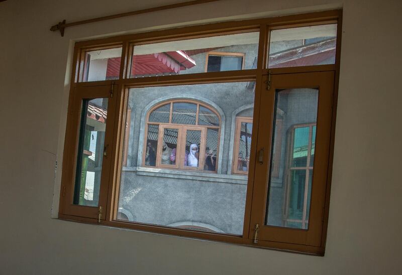 Neighbours of Indian policeman, Altaf Hussain, watch through a window his funeral procession in Srinagar, Indian-controlled Kashmir. Hussain was killed Tuesday when suspected rebels attacked Bharatiya Janata Party (BJP) leader Ghulam Qadir in Ganderbal district. AP Photo