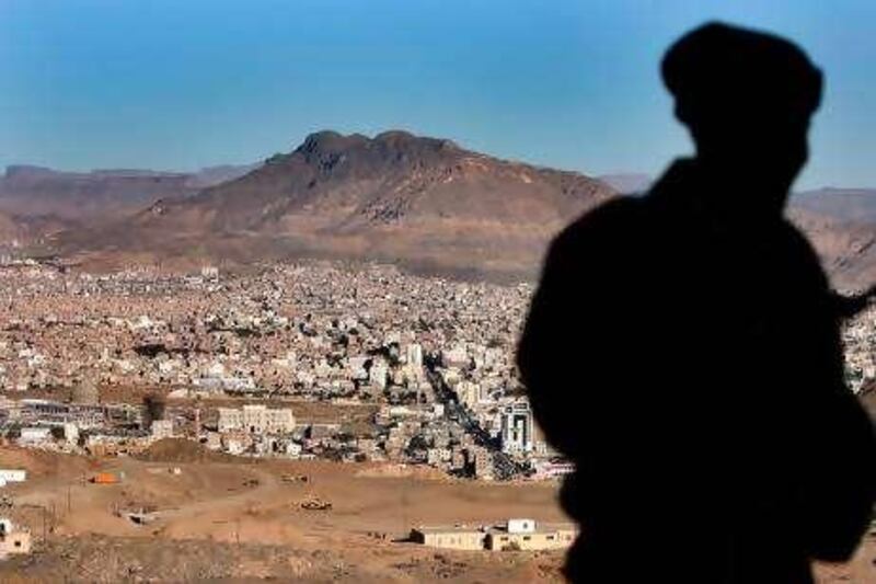 (FILES) -- File picture dated January 13, 2010 shows a Yemeni soldier standing on a hill overlooking the capital Sanna. Tribesmen abducted a Western couple and their Yemeni driver on May 24, 2010 in Bani Mansour, 70 kilometres (45 miles) west of the capital, a tribal source told AFP. AFP PHOTO/AHMAD GHARABLI *** Local Caption ***  596376-01-08.jpg
