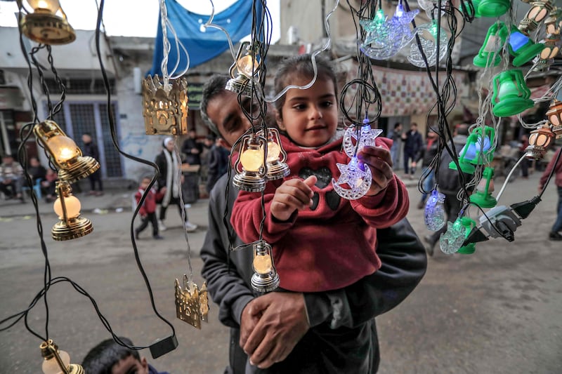 A child touches decorative lights and lanterns at a shop in Deir al-Balah in central Gaza. AFP