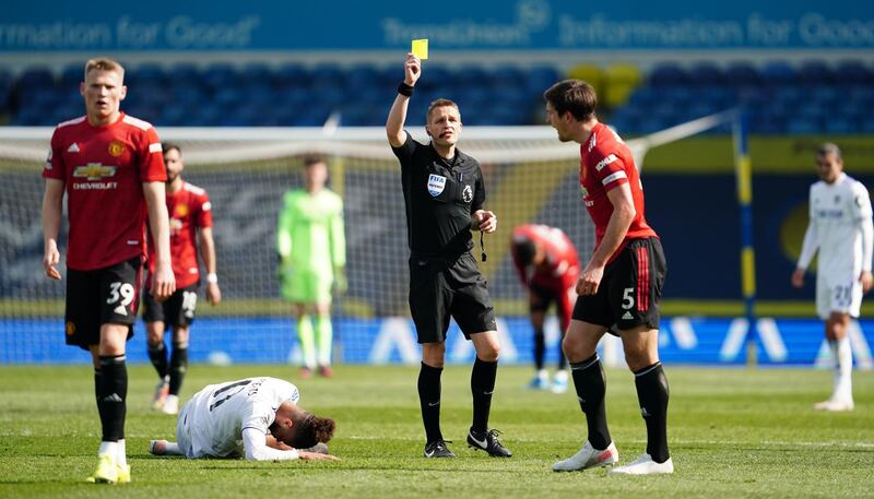 Referee Craig Pawson shows Harry Maguire of Manchester United a yellow card. Getty