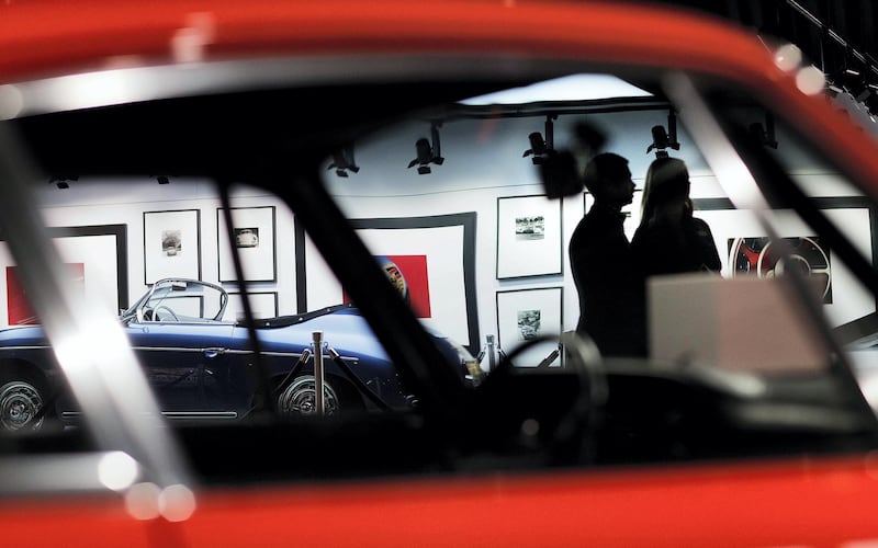 Guests walk through the Porsche Heritage Museum during the opening of the company's new North American headquarters, dubbed the Porsche Experience Center, Thursday, May 7, 2015, in Atlanta. The facility features a human performance fitness center, classic car gallery and restoration center in addition to a driving simulator lab and fine-dining restaurant overlooking a driver development track. (AP Photo/David Goldman)