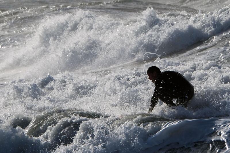 A surfer enjoys the waves at the Plage du David beach in downtown Marseille, southern France, as storm Eleanor hits part of France on January 4, 2018.   
Winter storm Eleanor swept across Europe on January 3, bringing death, damage and disruption, snarling transport networks and cutting power to tens of thousands of people. / AFP PHOTO / BORIS HORVAT