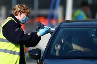 An NHS Track and Trace staff member collects samples at a drive-through test facility following an outbreak of the coronavirus disease (COVID-19) at a car park of Chessington World of Adventures in Chessington, Britain September 15, 2020.  REUTERS/Hannah McKay