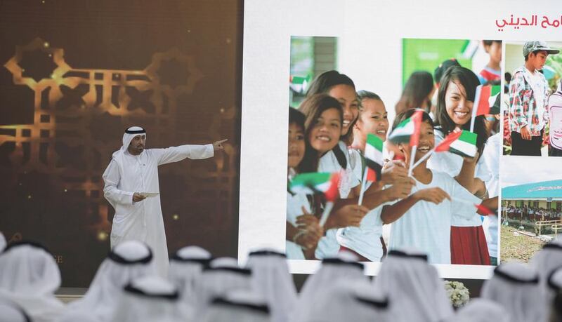 Emirates Red Crescent secretary general Mohammed Al Falahi at the Crown Prince Majlis alongside the image of the Filipino schoolgirls pleased that UAE aid helped rebuild their school. Courtesy Crown Prince Court 