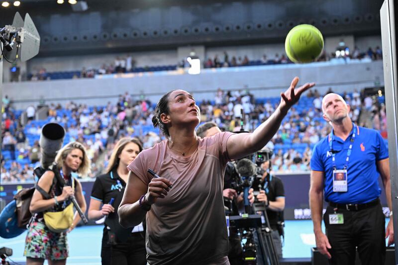 Ons Jabeur signs autographs for fans after her victory in the Australian Open first round. AFP