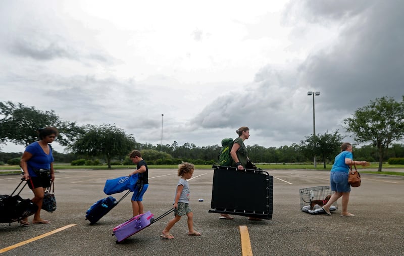 Evacuees stand in line to enter the Germain Arena, which is being used as a shelter in Estero, Florida. Gerald Herbert / AP Photo