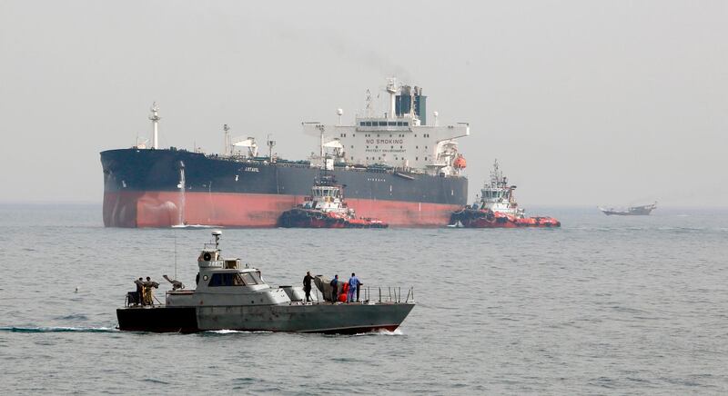 (FILES) In this file photo taken on March 12, 2017, an Iranian military speedboat patrols the waters as a tanker prepares to dock at the oil facility in the Khark Island, Iran. The US slapped fresh sanctions on Iran November 20, 2018, accusing it of creating a complex web of Russian cut-out companies and Syrian intermediaries to ship oil to Damascus, which in turn bankrolled Hezbollah and Hamas.    / AFP / ATTA KENARE
