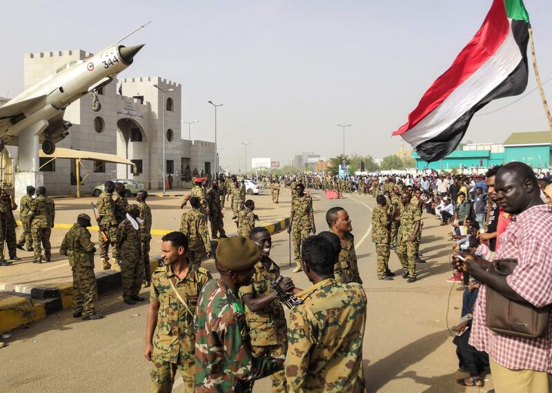 Sudanese soldiers stand guard as demonstrators continue their rally. AFP