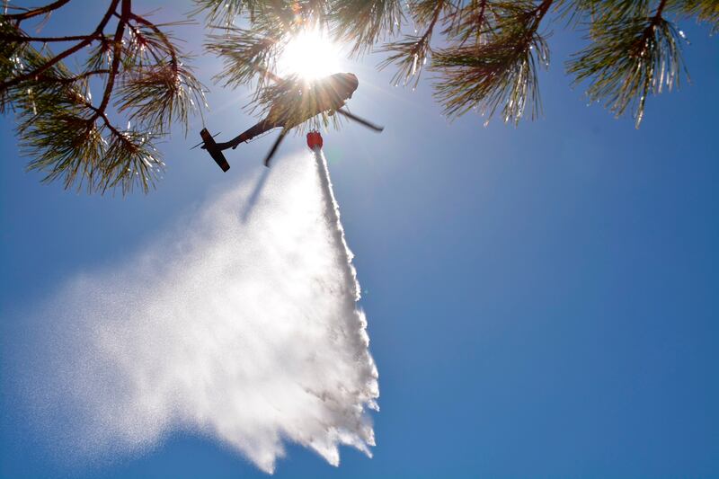 New Mexico National Guard Aviation soldiers drop water on the Calf Canyon and Hermits Peak fires in northern New Mexico. New Mexico National Guard / AP