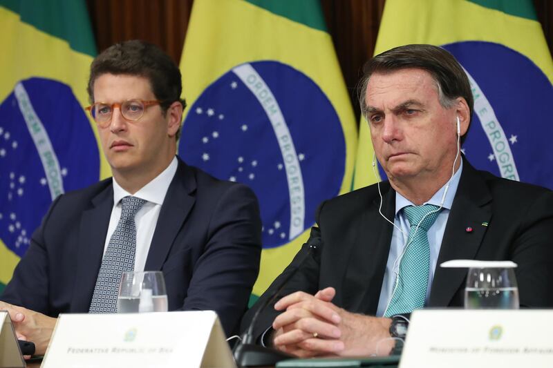 epa09152984 A handout photo made available by the Presidency of Brazil that shows President Jair Bolsonaro, along with the Minister of the Environment, Ricardo Salles (L), during the climate summit convened by the US President, Joe Biden, at the Planalto Palace in Brasilia, Brazil, 22 April 2021. Brazilian President Jair Bolsonaro announced that his country will seek to achieve carbon neutrality by 2050, ten years before the previous environmental commitment. Around 40 international leaders attended the summit called by US President Biden. The meeting is intended to underline the urgency and economic benefits of stronger climate action on the road to the United Nations Climate Change Conference (COP26) in Glasgow in November 2021.  EPA/MARCOS CORREA / BRAZIL PRESIDENCY / HANDOUT MANDATORY CREDIT: HANDOUT EDITORIAL USE ONLY/NO SALES