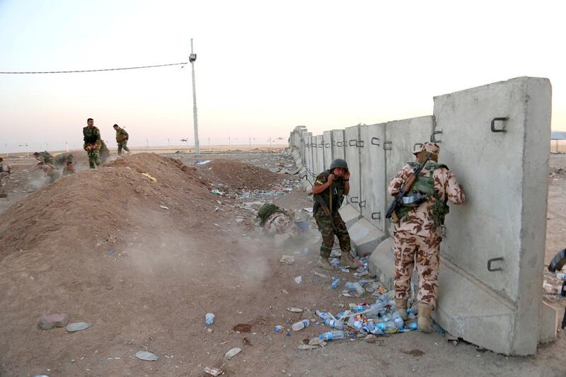 Kurdish peshmerga fighters take cover during airstrikes targeting Islamic State militants near the Khazer checkpoint outside of the city of Erbil in northern Iraq, on August 8, 2014. Khalid Mohammed / AP Photo