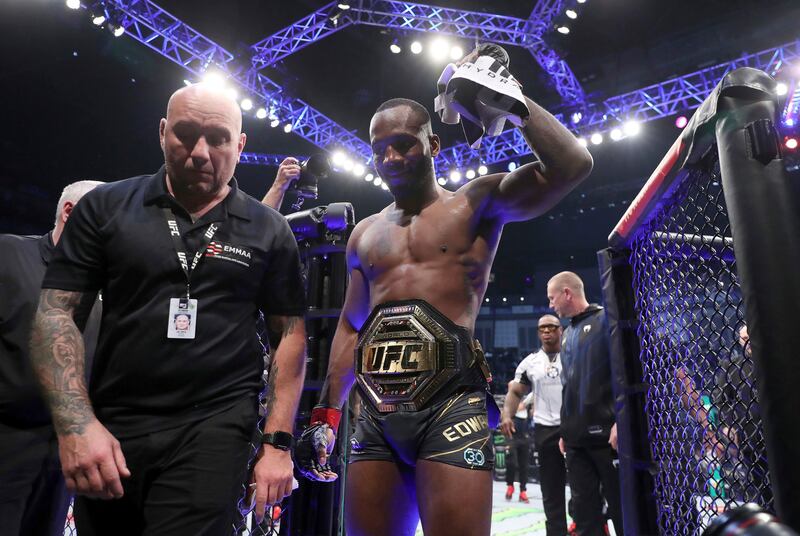 Leon Edwards, right, leaves the Octagon after victory against Kamaru Usman after their welterweight title bout at the UFC 286 mixed martial event at O2 Arena, in London, Saturday, March 18, 2023.  (Kieran Cleeves / PA via AP)