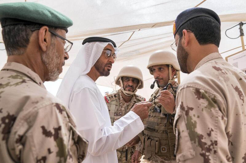 AL DHAFRA REGION, ABU DHABI, UNITED ARAB EMIRATES - April 08, 2018: HH Sheikh Mohamed bin Zayed Al Nahyan, Crown Prince of Abu Dhabi and Deputy Supreme Commander of the UAE Armed Forces (2nd L), and HE Lt General Hamad Thani Al Romaithi, Chief of Staff UAE Armed Forces (L), visit Al Hamra Camp, prior to a military exercise titled ‘Homat Al Watan 2 (Protectors of the Nation)’.
 ( Mohamed Al Hammadi / Crown Prince Court - Abu Dhabi )
---