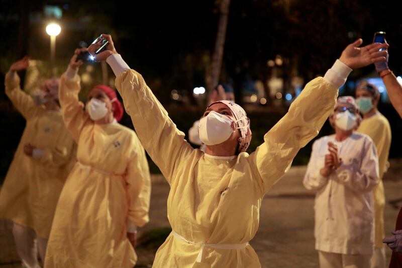 Health workers gesture as citizens show their support from their balconies and windows, amid the spread of the coronavirus disease (COVID-19), in Barcelona, Spain. REUTERS