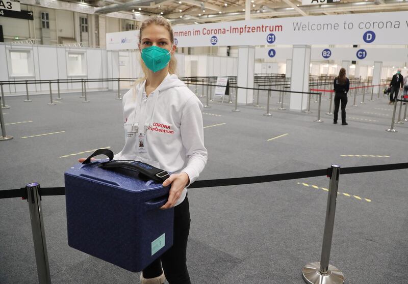 A staff member poses with a box containing vaccine doses in Hamburg, northern Germany. EPA