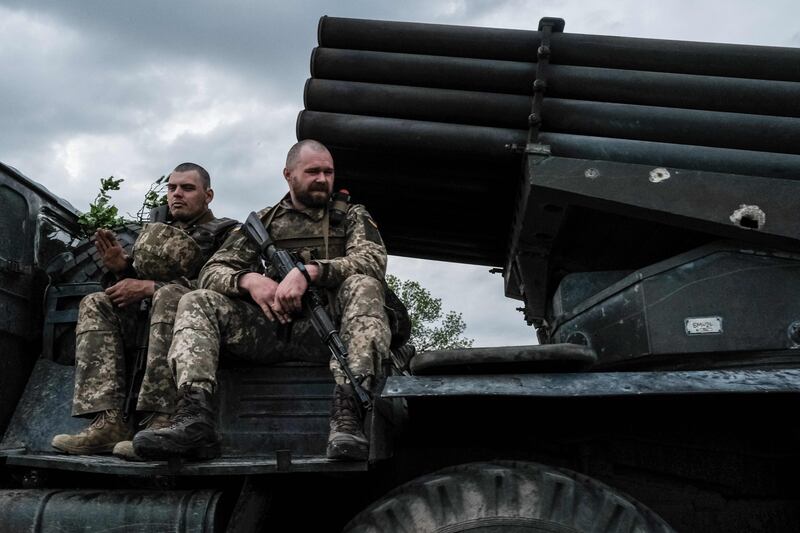 Ukrainian soldiers ride on a vehicle carrying a rocket launcher in eastern Ukraine. AFP