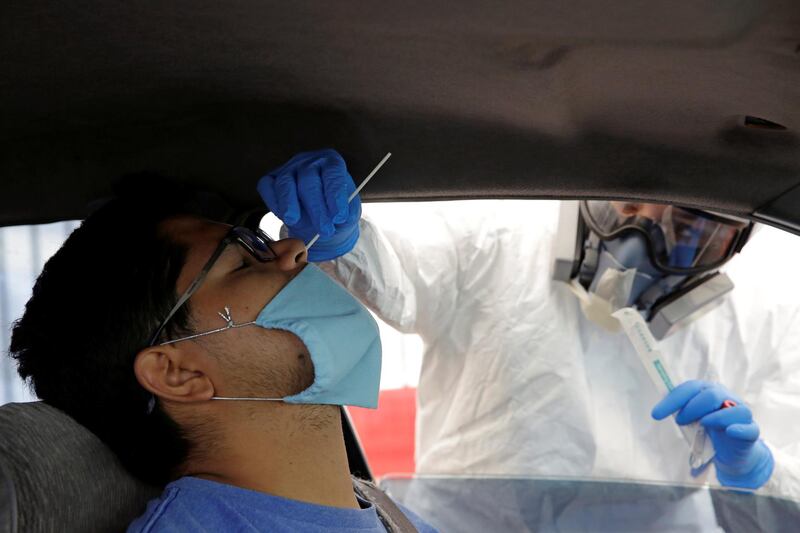 A healthcare worker collects a swab sample for Covid-19 at a drive-thru testing site in Ciudad Juarez, Mexico. Reuters