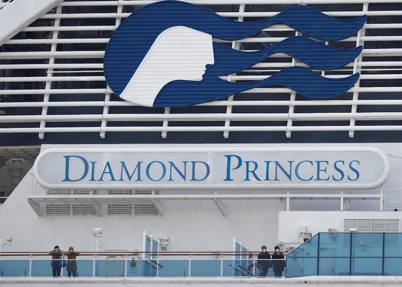 Masked passengers look on from on board the coronavirus-hit Diamond Princess cruise ship docked at Yokohama Port, south of Tokyo, Japan, February 20, 2020. REUTERS/Kim Kyung-Hoon