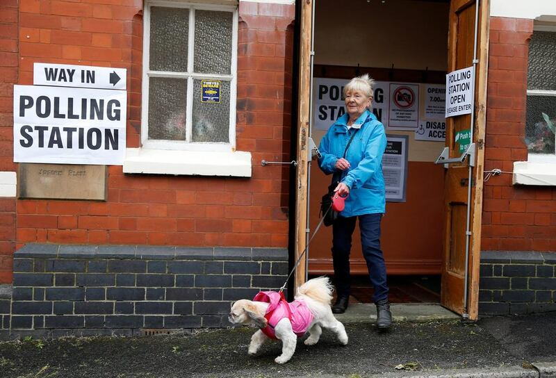A voter leaves the polling station with her dog in Congleton, northern England. Reuters
