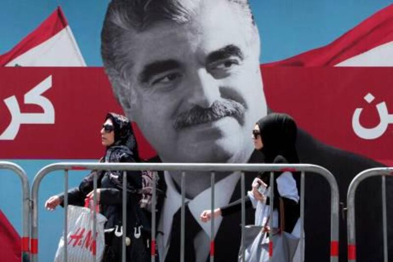 Lebanese women pass by a giant portrait of slain Lebanese Prime Minister Rafik Hariri near his grave, in downtown Beirut, Lebanon, on Thursday June 30, 2011. A U.N.-backed court investigating the 2005 assassination of former Prime Minister Rafik Hariri delivered an indictment and four arrest warrants Thursday, the latest turn in a case that has transformed the Arab nation and brought down the government earlier this year. The names of the accused were not released, but the court has been expected to accuse members of the Iran-backed militant group Hezbollah. (AP Photo/Hussein Malla) *** Local Caption ***  Mideast Lebanon Hariri Tribunal.JPEG-0f9d8.jpg