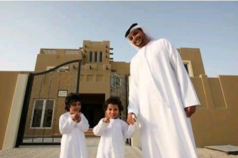 Abdullah Al Jeaid, pictured with his sons, collected his villa keys yesterday.