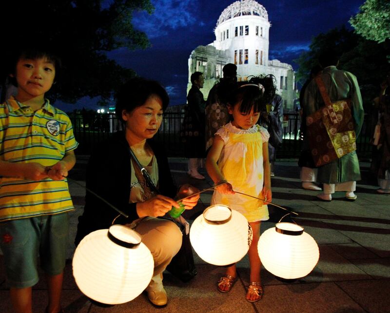 Mother and her children wait to take part in a lantern parade by Buddhist followers in prayer for peace around the illuminated Atomic Bomb Dome in Hiroshima, western Japan on the eve of the 66th anniversary of the world's first atomic bombing on the city, Friday, Aug. 5, 2011. (AP Photo/Koji Sasahara) *** Local Caption ***  Japan Hiroshima Anniversary.JPEG-0ad61.jpg