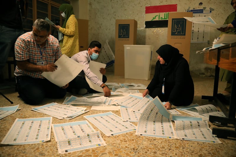 Iraqi election committee staff members count votes at the end of Sunday's parliamentary election day at a polling station in Baghdad's Karada district.  EPA