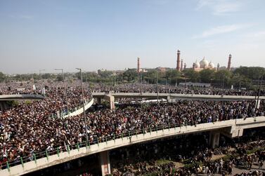 People gather to attend funeral services for Khadim Hussain Rizvi, leader of religious and political party Tehreek-e-Labaik Pakistan (TLP), with Badshahi Mosque in the background, as the outbreak of the coronavirus disease (COVID-19) continues, in Lahore, Pakistan November 21, 2020. REUTERS/Mohsin Raza