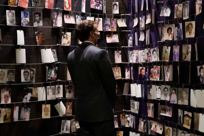 French President Emmanuel Macron looks at the images of genocide victims during a visit to the Kigali Genocide Memorial in Rwanda. About 250,000 victims of the 1994 massacres are buried in Kigali. AFP